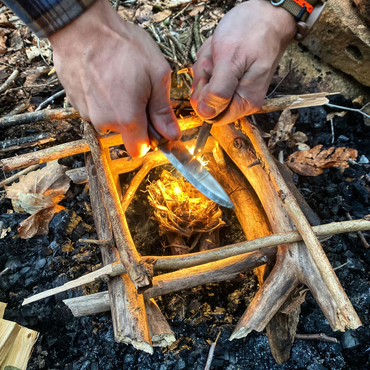 rozdmuchiwanie płomienia w pełne ognisko mały płomień na hubce rozdmuchiwany w ognisko z gałęziami