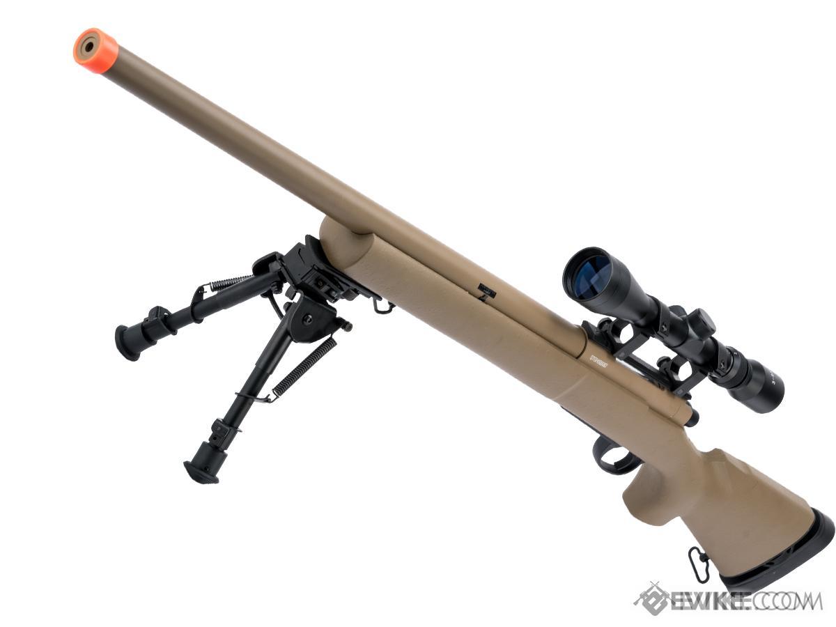 mężczyzna manualnie przeładowujący snajperkę spring ASG w lesie