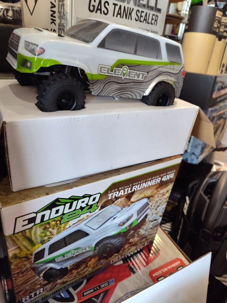 sterownik RC z wyświetlaczem w rękach mężczyzny obok modelu terenowego na stole