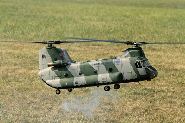 młody chłopiec sterujący modelem helikoptera RC na trawniku